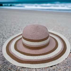 pink wide brimmed sunhat on beach