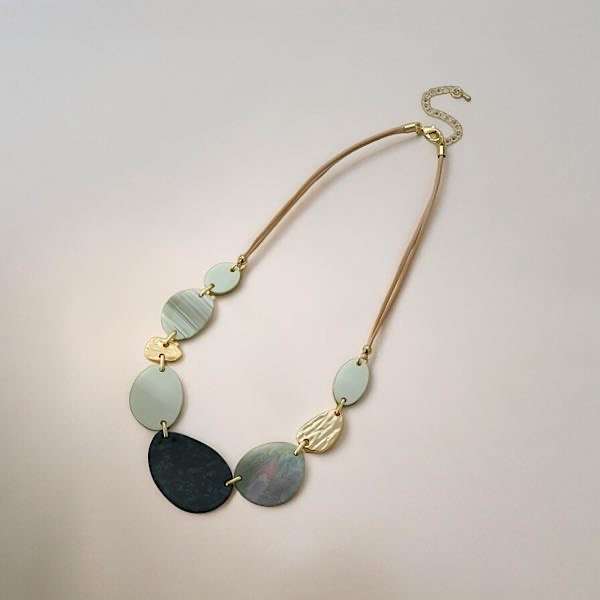 gold resin short necklace on plain background