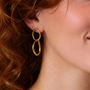 woman wearing gold organic hoop earrings
